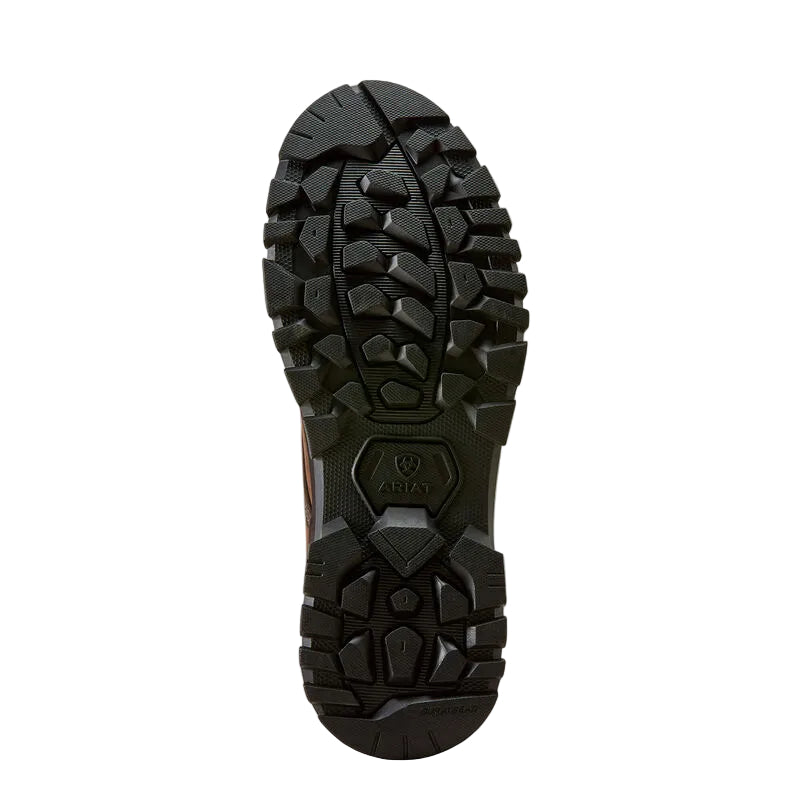 A close-up, top-down view of a rugged black outdoor boot sole, showing deep lugs and a textured tread pattern on a light beige background.