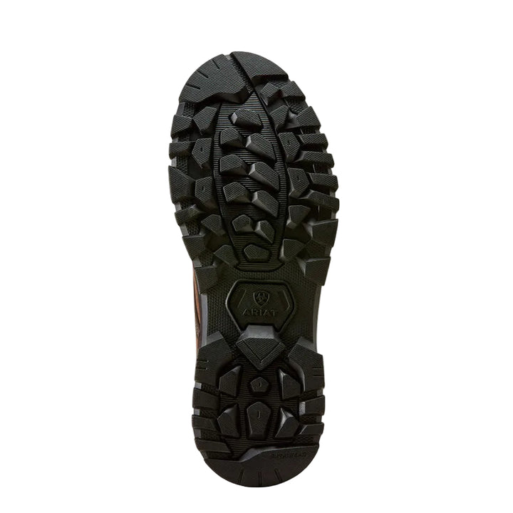 A close-up, top-down view of a rugged black outdoor boot sole, showing deep lugs and a textured tread pattern on a light beige background.