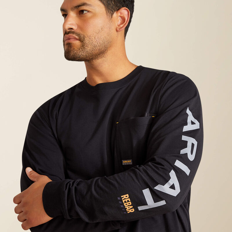 Man wearing a black long-sleeve shirt with 'ARIAT' branding on a beige background