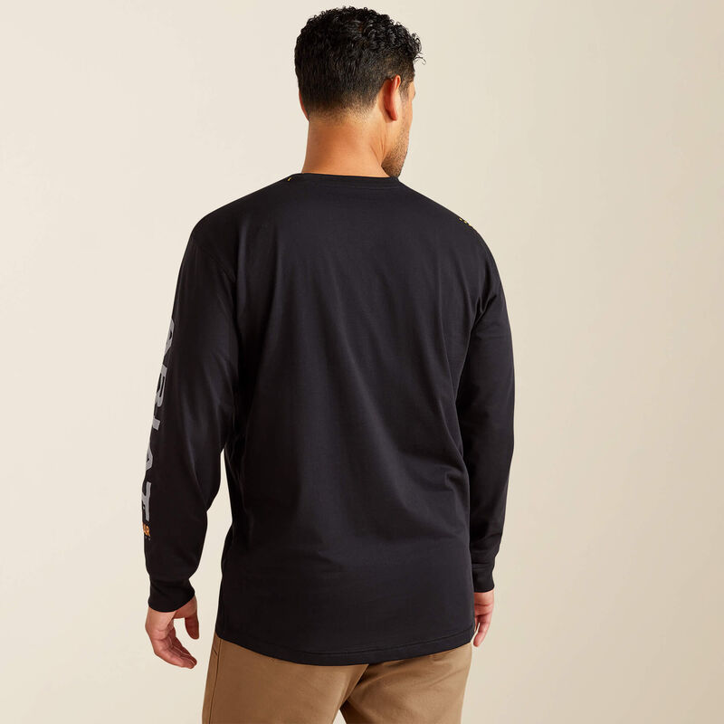 Man wearing a black long-sleeve shirt with a logo on the back, standing against a beige background