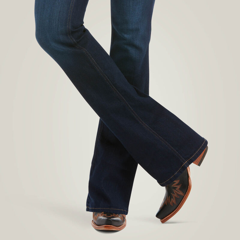 Ariat R.E.A.L. High Rise Ballary Boot Cut Jeans in Pennsylvania wash, close-up showing dark blue denim, bootcut leg openings and stitching over western boots.