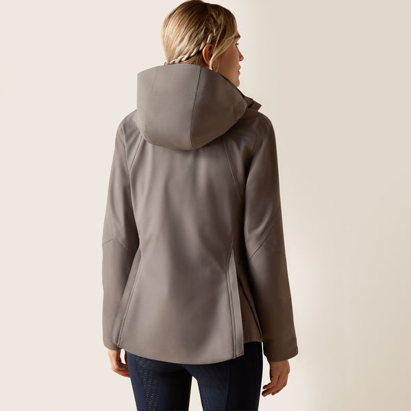 Woman wearing a gray hooded jacket on a plain background