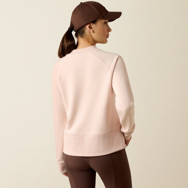 Person wearing a pink sweatshirt and brown cap on a beige background