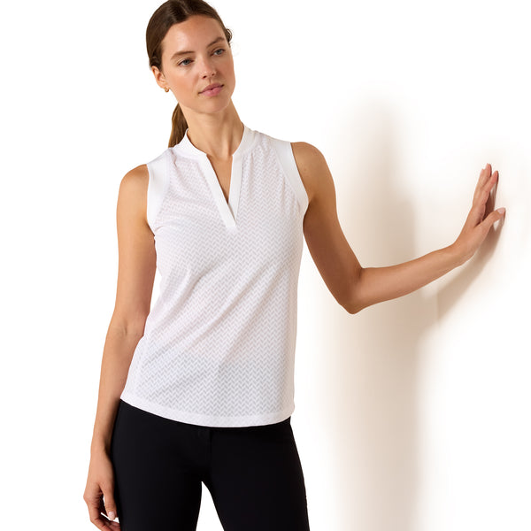 Woman wearing a white sleeveless top with a pattern against a plain background