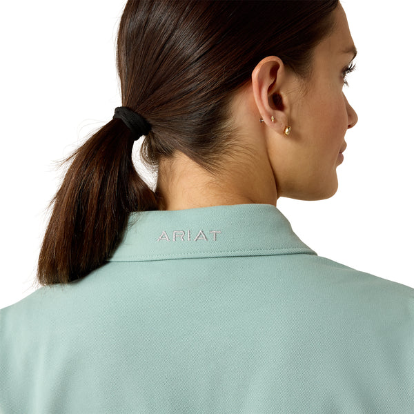 Person wearing a light blue Ariat shirt with a white background