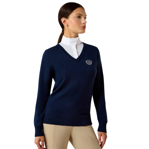 Woman wearing a navy sweater with a logo on a white background