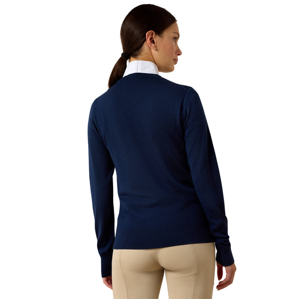 Woman wearing a navy blue sweater and beige pants on a white background