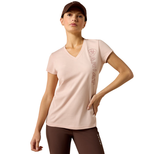 Woman wearing a light pink t-shirt with a brand logo on a white background
